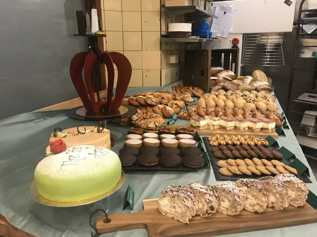 Prinsesstårta med texten The Big Apple, mazariner, chokladbiskvier och bakelser på det uppdukade bordet